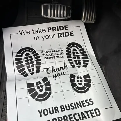 A printed thank-you sheet on a floor mat: we take pride in your ride